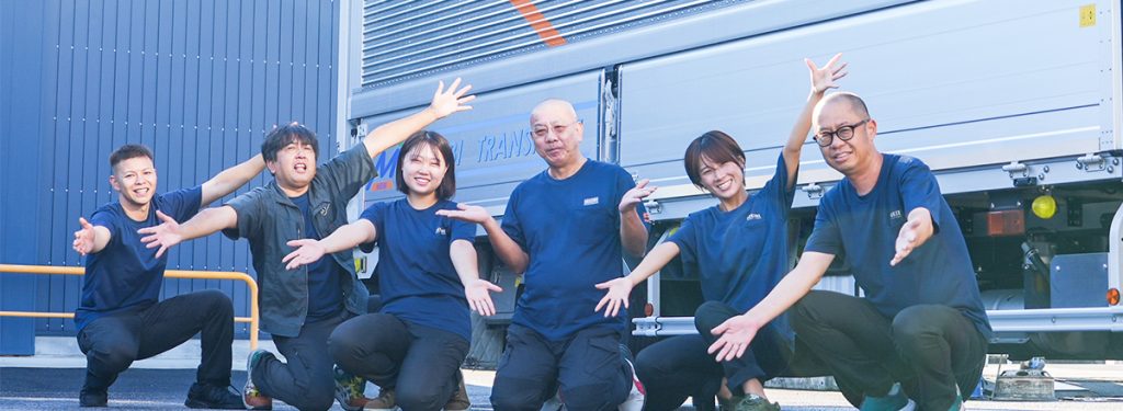 トラックの前でポーズをするスタッフの集合写真