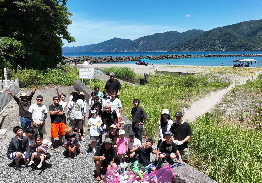 スタッフとご家族で海岸清掃する様子