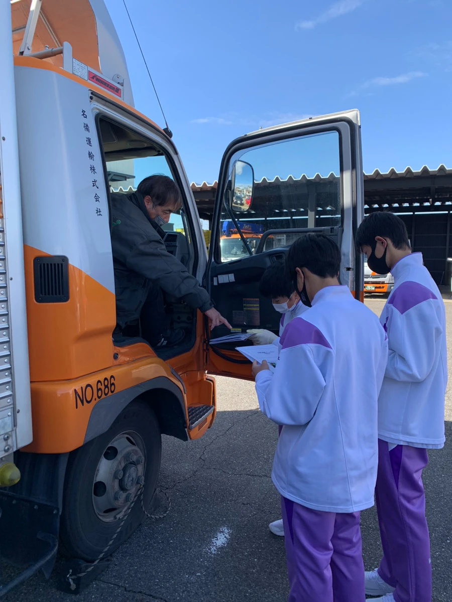中学生がトラックのドライバーにインタビューする様子